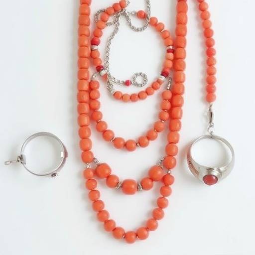 Un primo piano di gioielli italiani, tra cui collane in corallo, bracciali in argento e orecchini con pietre preziose.